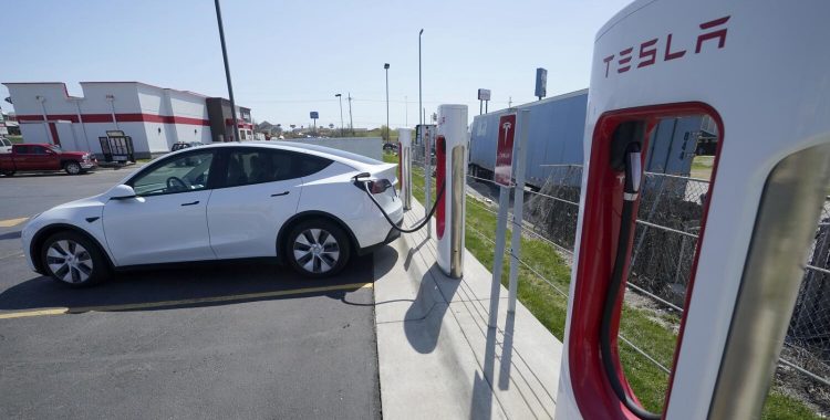 A Tesla charges at a station.