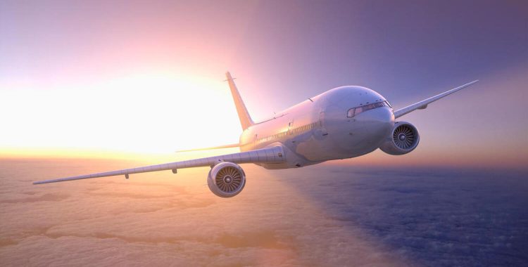 Airplane flying above clouds at sunset