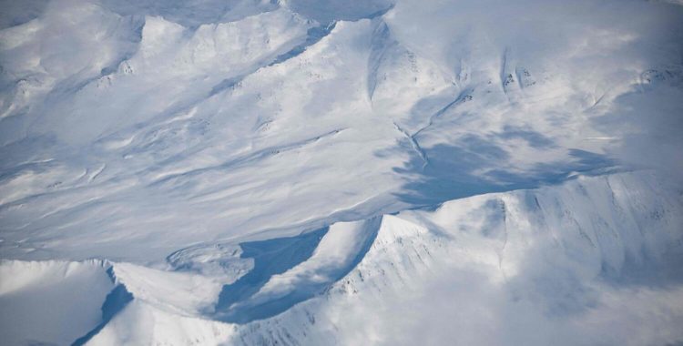 This file photo taken on May 2, 2022, shows a view of snow covered mountains, viewed through a window of an airplane on the way to Longyearbyen, in Svalbard Archipelago, northern Norway. — AFP